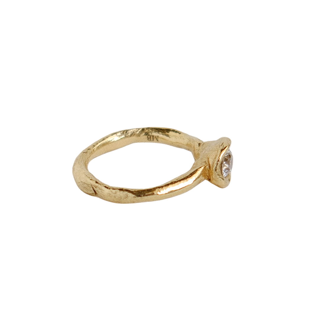 Organic gold ring with a round antique diamond on a white background