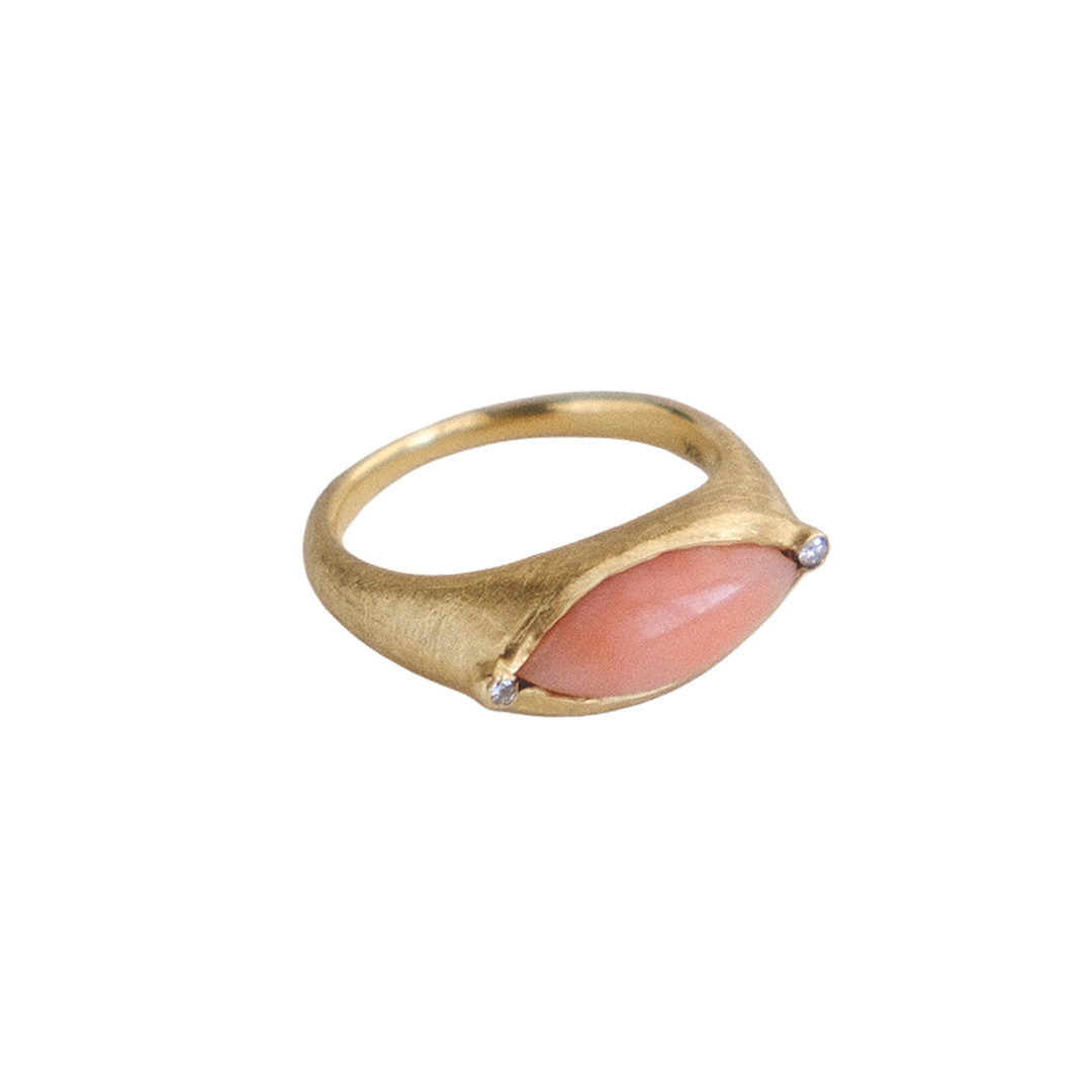 Gold ring with a pink stone on a white background