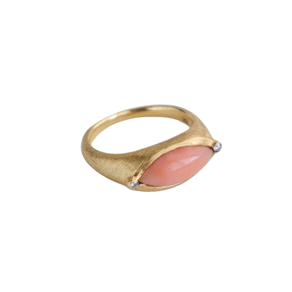 Gold ring with a pink stone on a white background