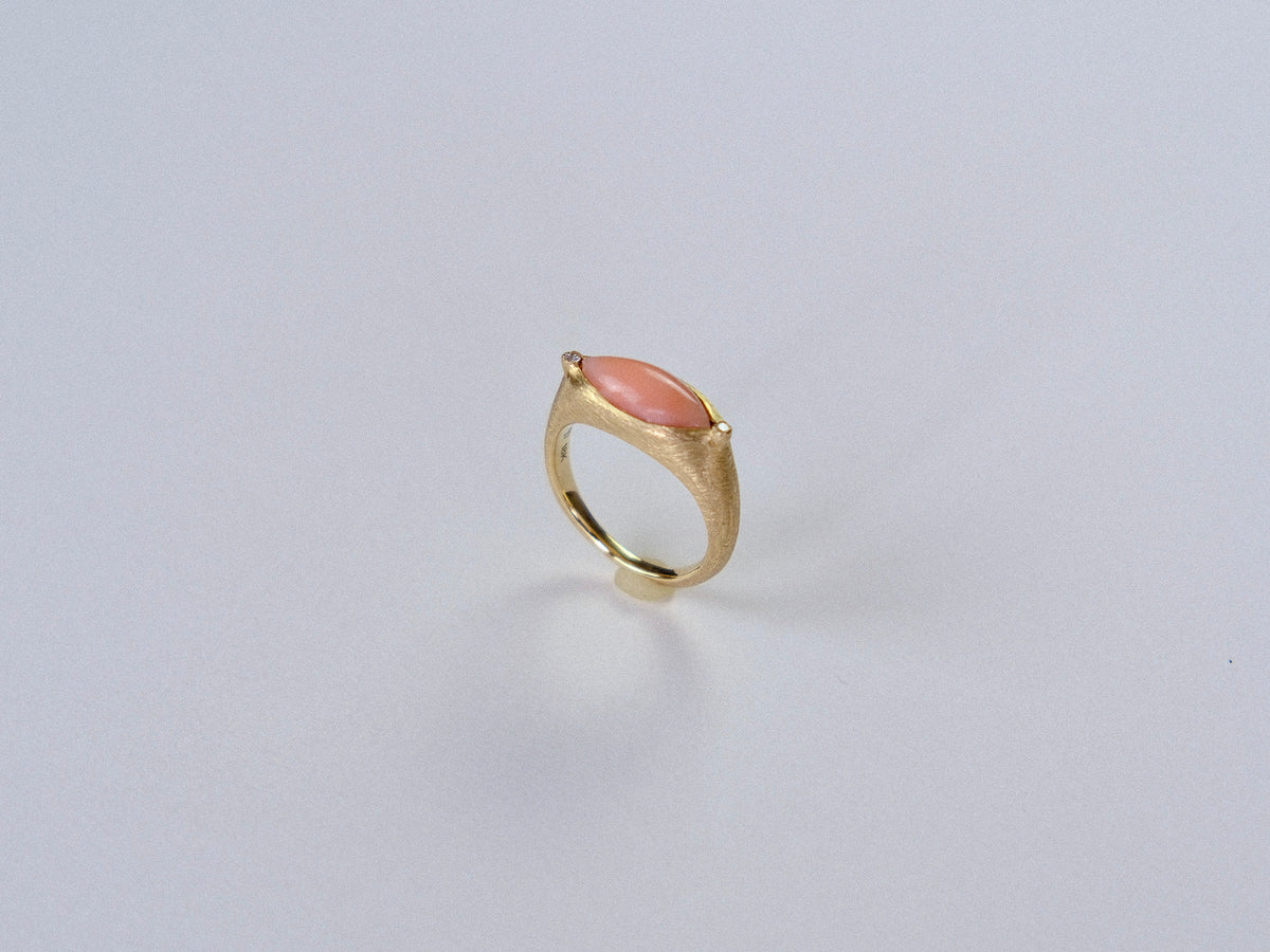 Gold ring with a  largepink stone on a light gray background