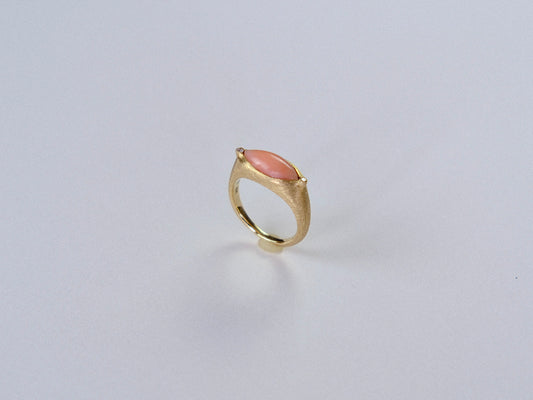 Gold ring with a  largepink stone on a light gray background