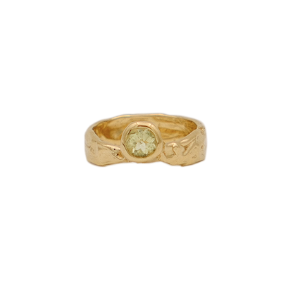 Gold ring with a green gemstone on a white background
