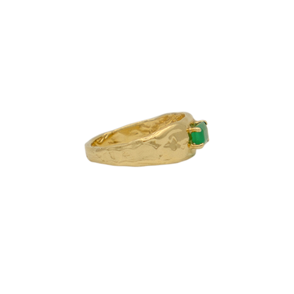 Organic gold ring with a green gemstone on a white background