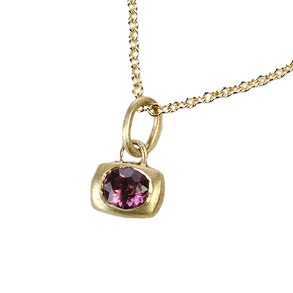 Gold necklace with a purple gemstone pendant on a white background