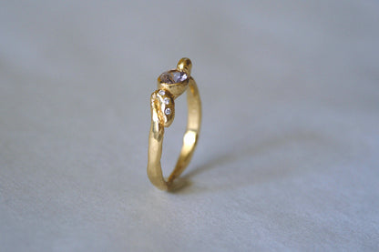 Ring with lavender purple gemstone against gray background.