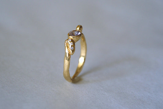 Ring with lavender purple gemstone against gray background.