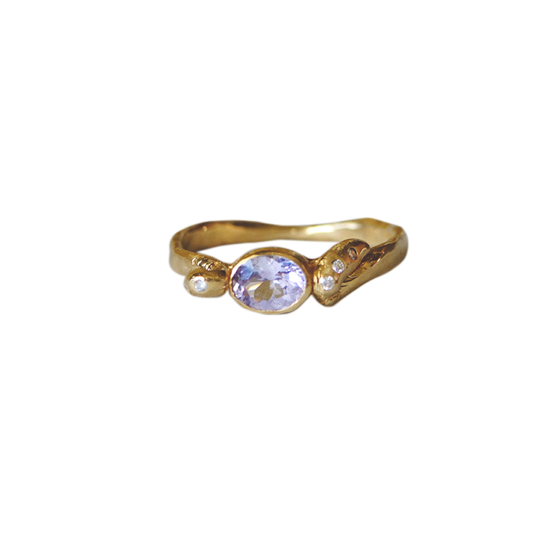 Gold ring with a lavender gemstone on a white background