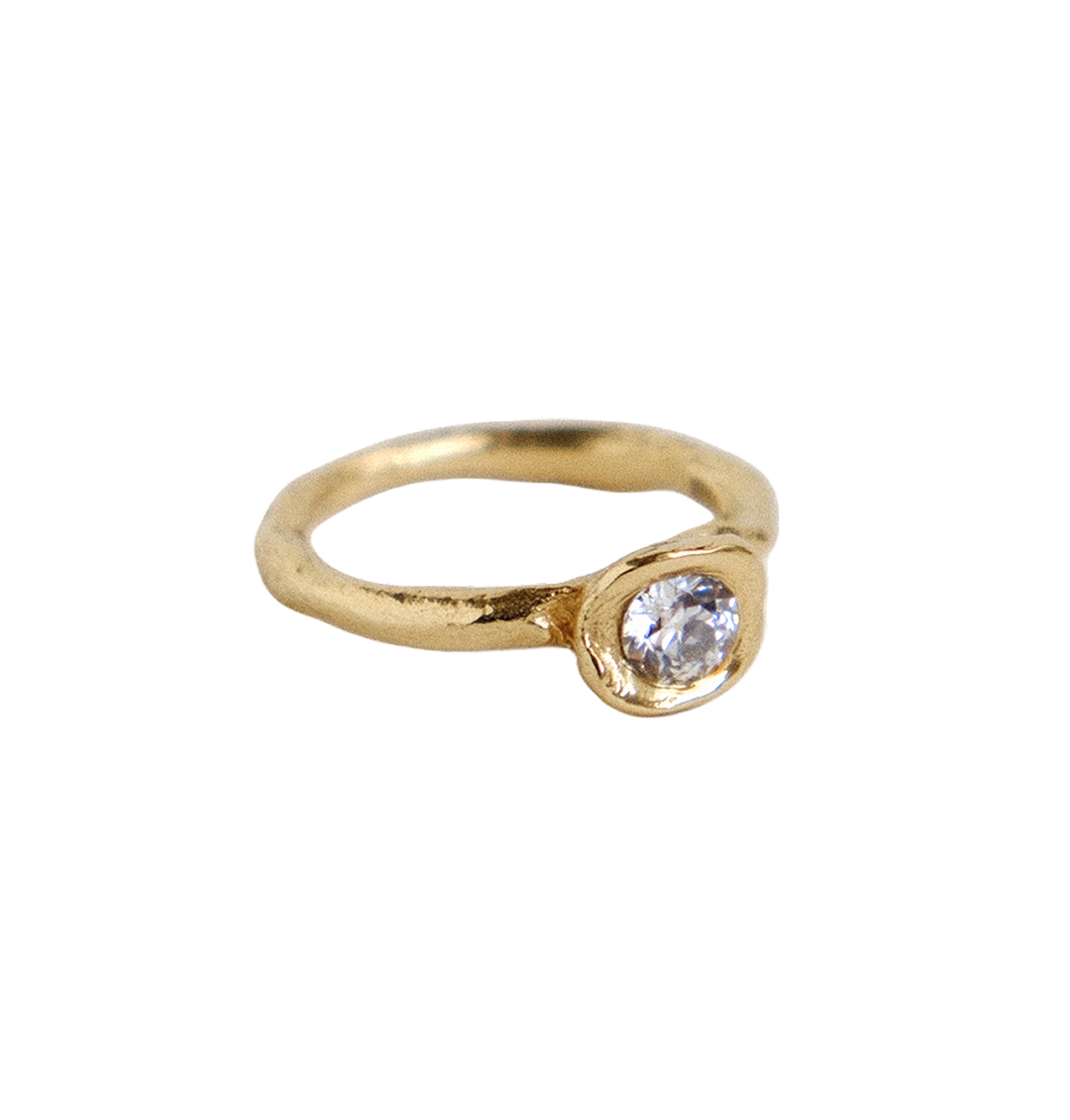 Organic gold ring with a round antique diamond on a white background