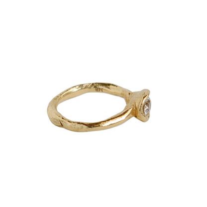 Organic gold ring with a round antique diamond on a white background